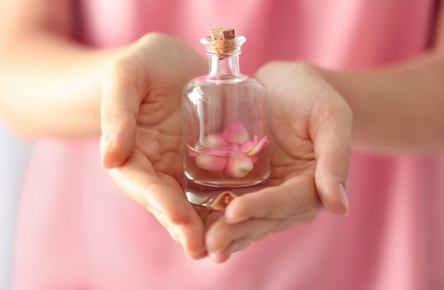 Woman holding bottle of aroma oil closeup