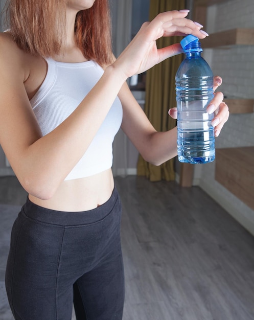 Photo woman holding bottle of water exercise at home