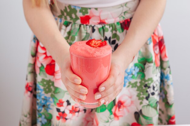 Woman holding bottle with delicious smoothie close up