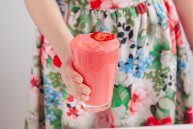 Woman holding bottle with delicious smoothie close up