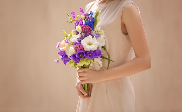 밝은 배경에 아름다운 꽃 꽃다발을 들고 있는 여자