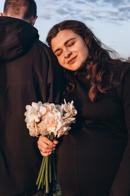 Foto donna con un bouquet di fiori accanto a un uomo