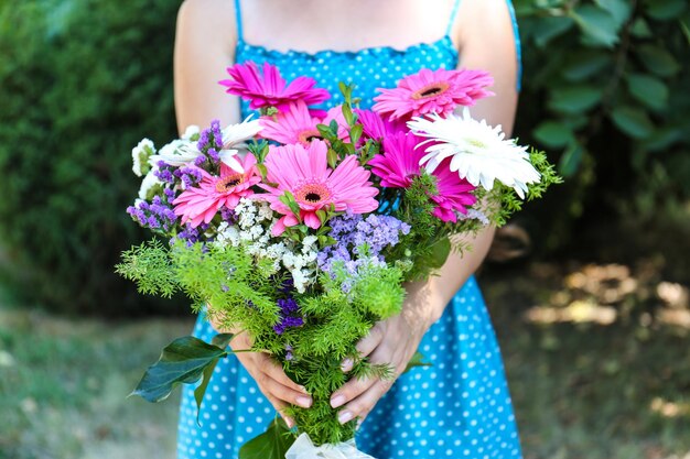 ピンクの花の花束を持っている女性