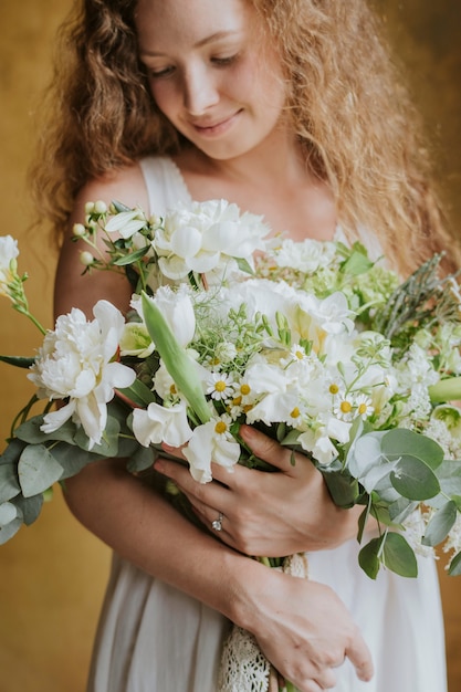 Donna con in mano un mazzo di fiori bianchi