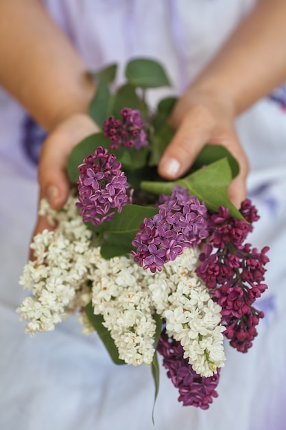 Woman holding bouquet of white lillak in his hahd