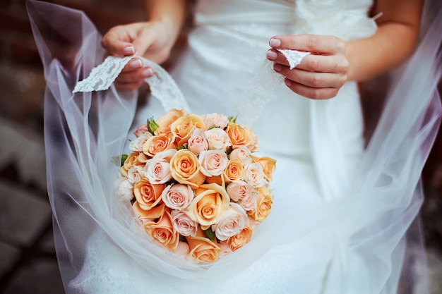 Woman holding  bouquet with her hands on wedding day. 