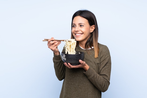 Woman holding a bowl of noodles with chopsticks