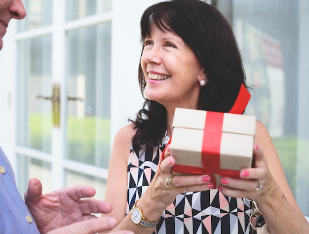 Woman holding a box of present with red bow