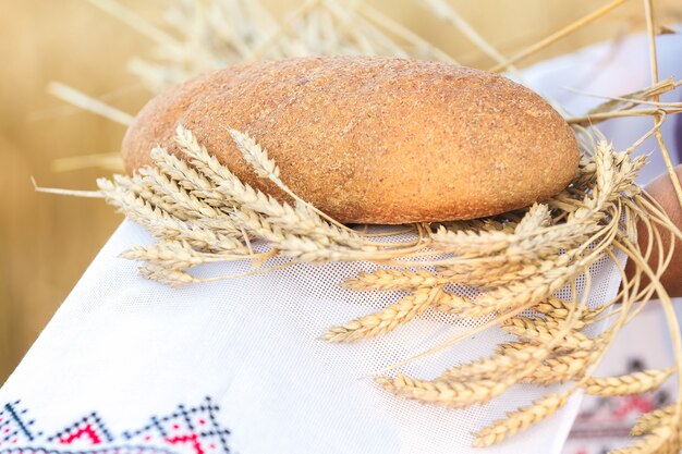 The woman holding a  bread and grain