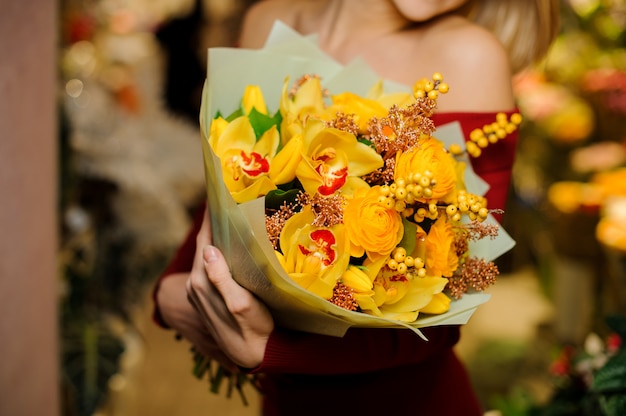 バレンタインのsの明るい黄色の花の花束を保持している女性