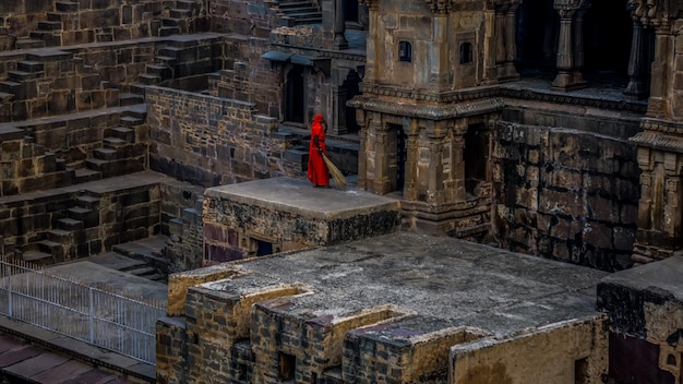 Foto donna con una scopa in piedi su un edificio storico