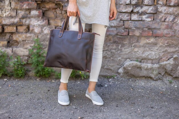 Фото Женщина держит коричневые кожаные рюкзаки в руке сумка унисекс