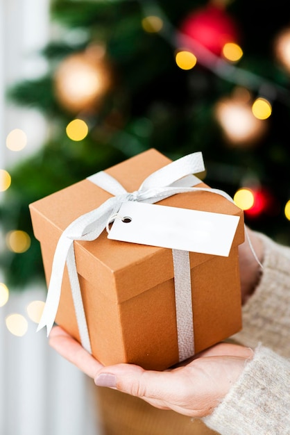 Woman holding a brown present with a white card