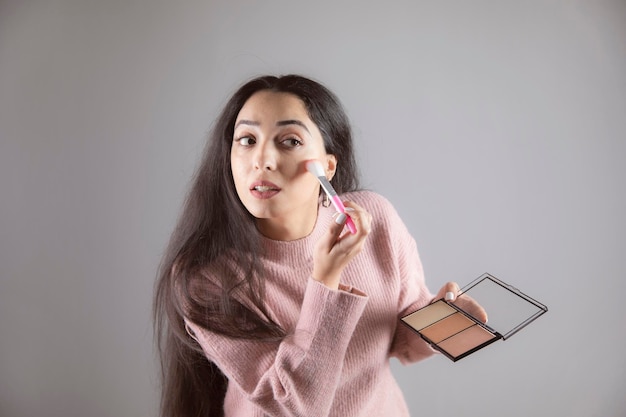 Woman holding brush and highlighter