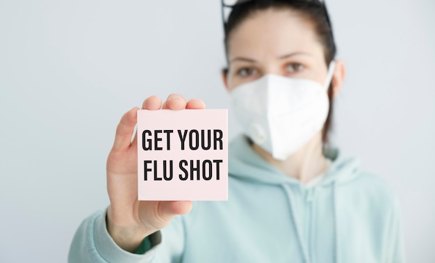 Photo woman holding a card with get your flu shot, medical concept