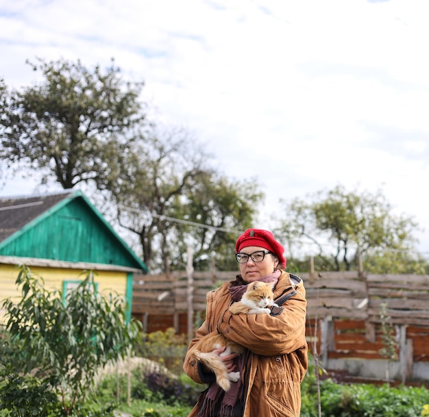 Photo a woman holding a cat in her arms in a field