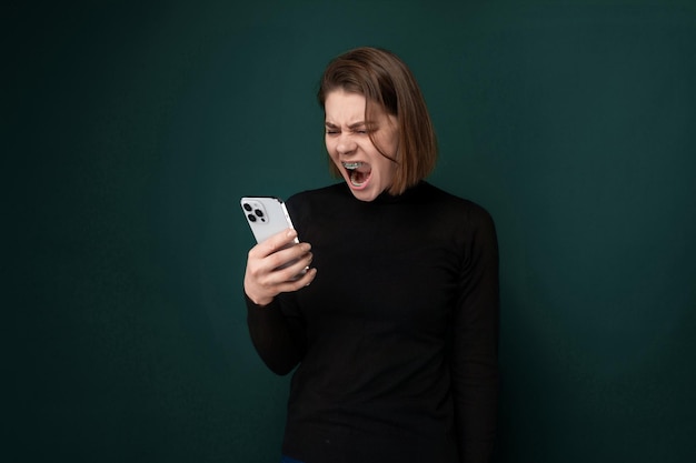 Photo woman holding cell phone with open mouth