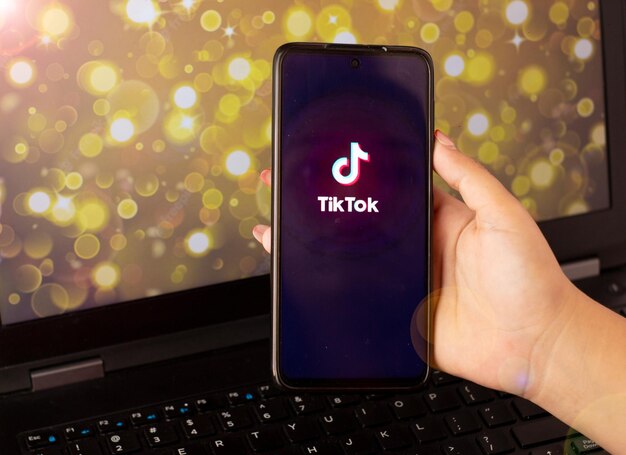 Photo woman holding a cell phone with tiktok open