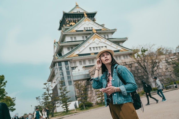 屋外に立っている携帯電話を保持している女性