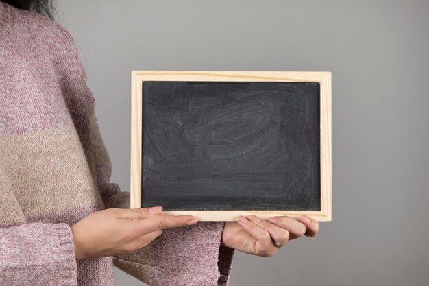 Woman holding chalkboard or blackboard