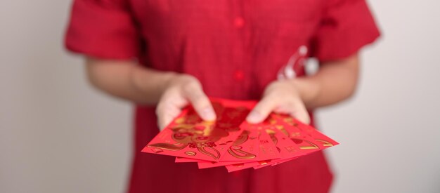 Woman holding Chinese red envelope money gift for happy Lunar New Year holiday