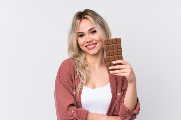 Woman holding chocolate over isolated wall