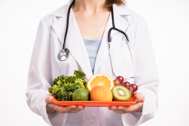 Photo woman holding a chopping board  with fruit