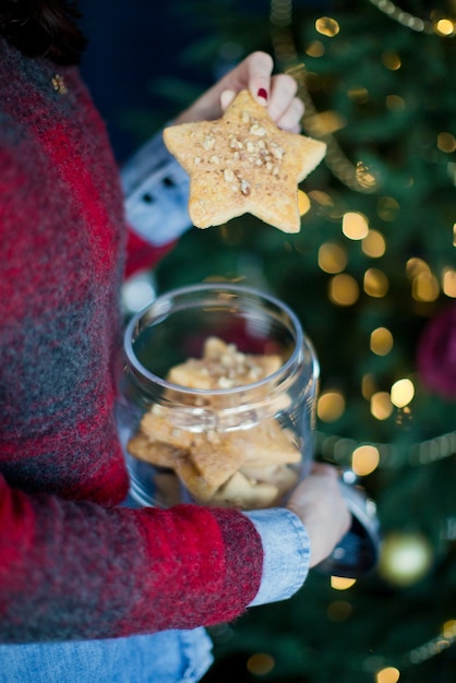 クリスマスのクッキーを保持している女性