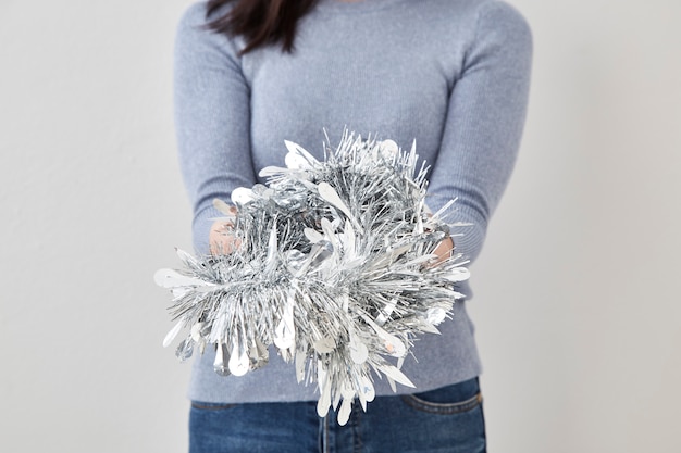 Woman holding christmas silver tinsel