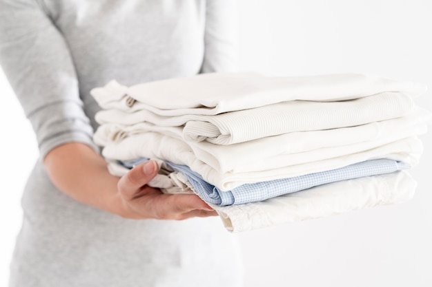 Photo woman holding clean pile of clothes