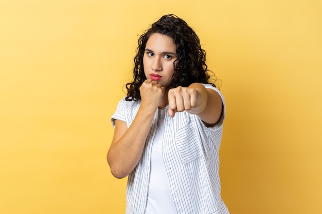 Woman holding clenched fists up fighting with abuser defence from domestic violence