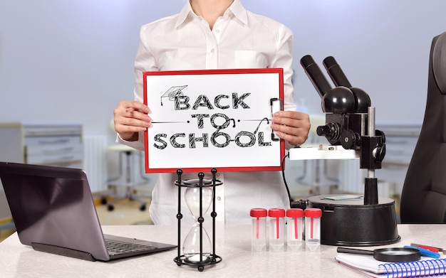 Woman holding clipboard with back to school