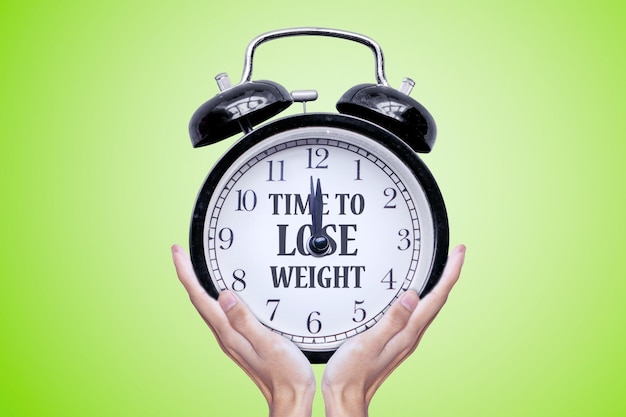 Woman holding clock with time to lose weight text