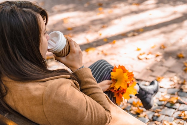Foto donna che tiene una tazza di caffè da bere per andare nella stagione autunnale