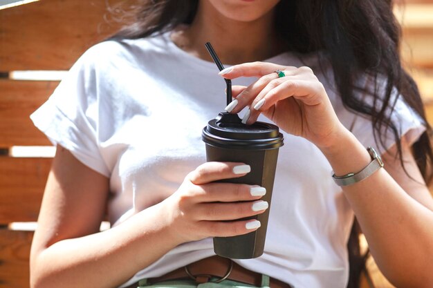 写真 通りでコーヒーを保持している女性