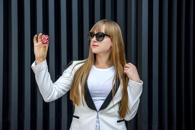 Woman holding colorful poker chips. Gambling theme