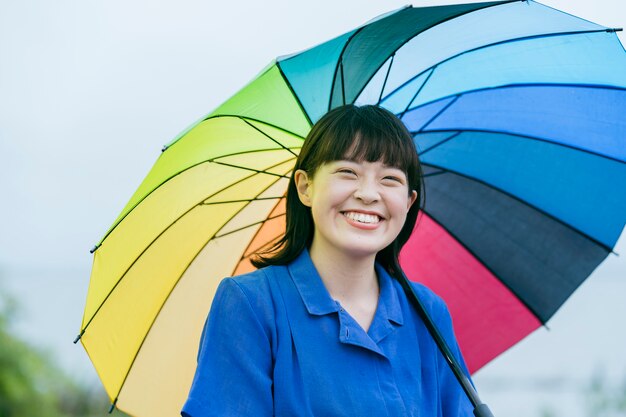 雨の中で色とりどりの傘を持っている女性