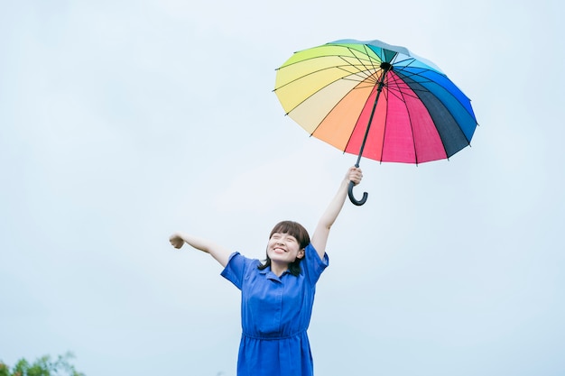 雨の中で色とりどりの傘を持っている女性