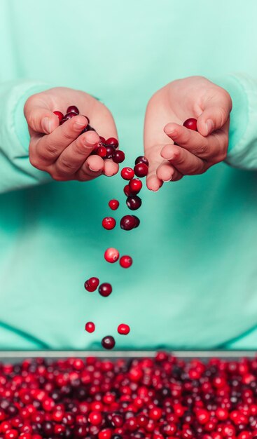 Woman holding cranberries in her hands close up