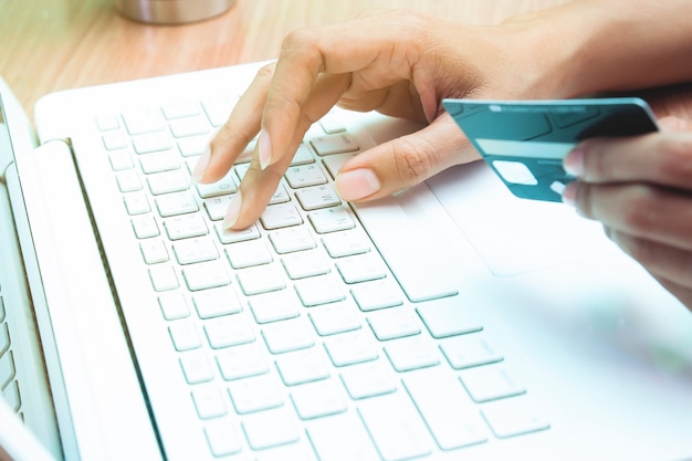 Woman holding credit card on laptop. Online shopping, Online banking concept