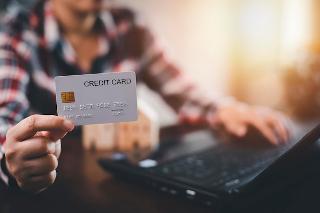 Woman holding credit card for makes a purchase on the Internet on the laptop computer with credit card online payment shopping online ecommerce internet banking spending money concept