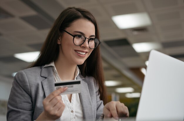 Woman holding credit card, shopping online, booking tickets on website