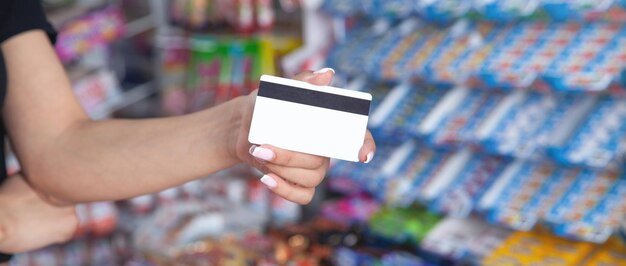 Photo woman holding credit card at supermarket