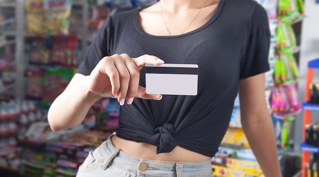 Photo woman holding credit card at supermarket.