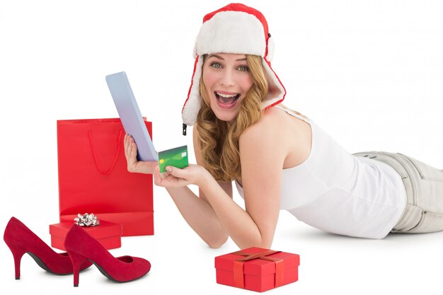 Женщина, держащая кредитную карту, окруженную подарками