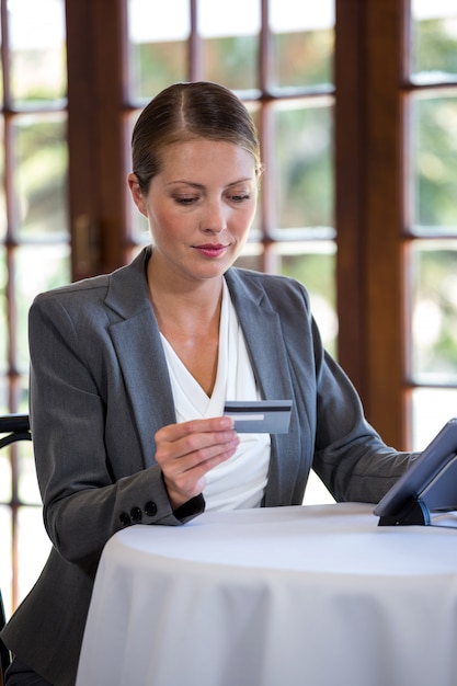 Woman holding credit card and tablet