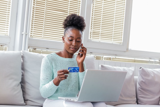 Woman holding credit card and talking on the phone