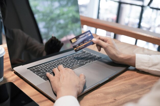Woman holding credit card and using laptop computer Online shopping concept
