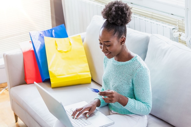 Woman holding credit card and using a laptop