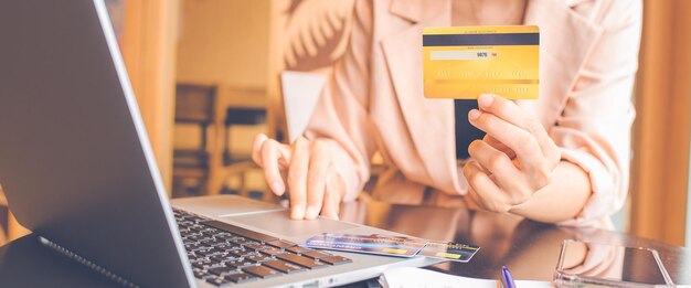 Photo woman holding credit cards and using laptops shopping online